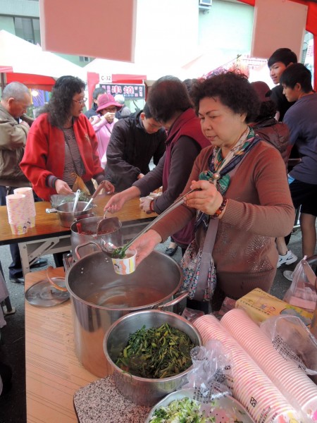 婆婆媽媽們忙著裝料、舀湯，讓民眾免費品嚐眷村美味。（記者林孟婷攝）