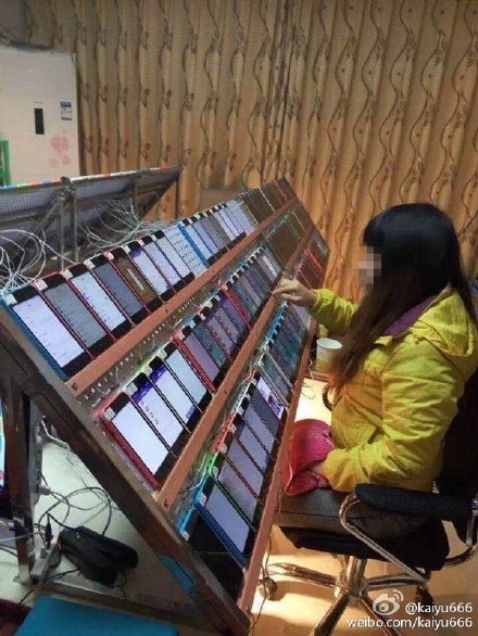 一名女孩坐在大量iPhone前操作，據網友說法，這就是中國的「刷榜工作室」。（圖擷取自微博）