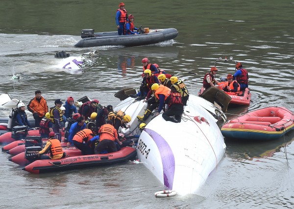 復興航空墜河現場，救難人員救援中。（記者方賓照攝）
