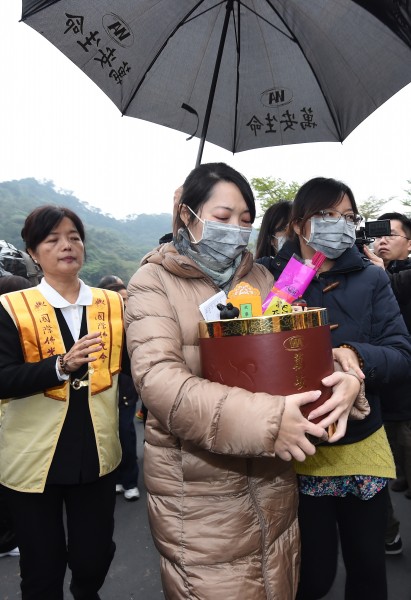 機師廖建宗的妻子昨日手捧著牌位回靈堂安置。（記者劉信德攝）