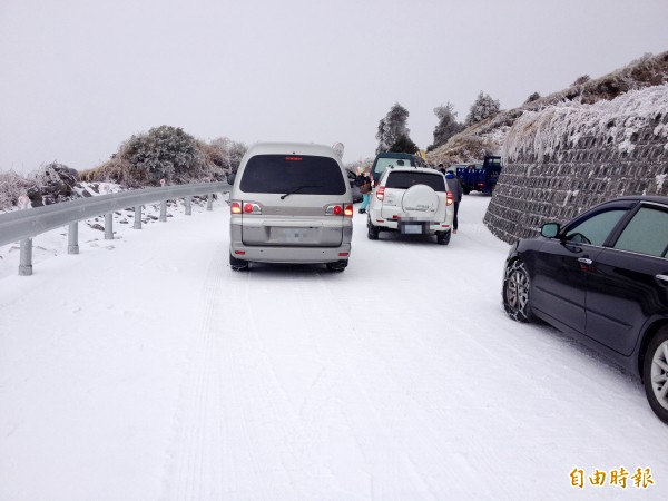 合歡山今日再降瑞雪，鳶峰以上路段一片雪白，車輛都加掛雪鏈。（記者陳鳳麗攝）