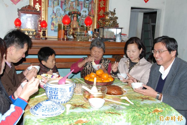 草屯鎮長洪國浩（右一）在新豐里長陳美玲（右二）等人陪同下，送年菜給獨居的王老太太（右三），一群人並提早團圓吃湯圓。（記者陳鳳麗攝）