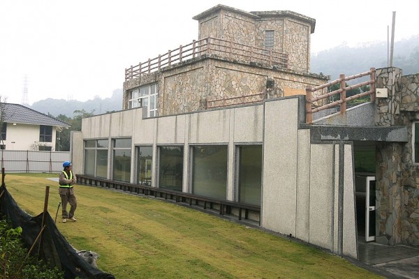 An inspector surveys illegal buildings constructed by Liu Cheng-chih in Yangmingshan National Park in Taipei yesterday.
Photo: CNA