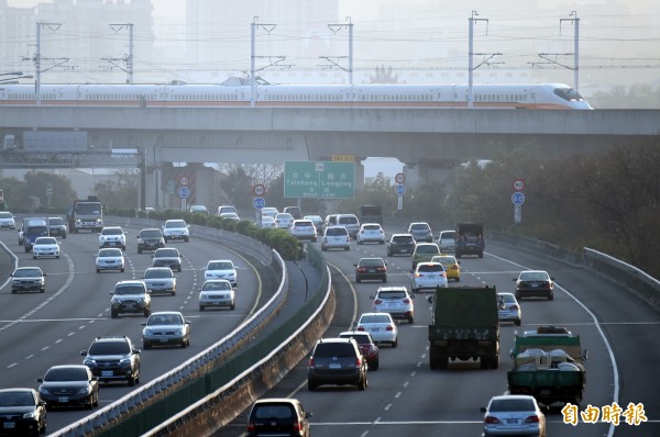 小年夜前民眾趕回家過年，中山高速公路出現局部車多擁擠現象，高鐵快速行駛經過國道上方，似在與國道上車輛互相比拚。（記者廖耀東攝）