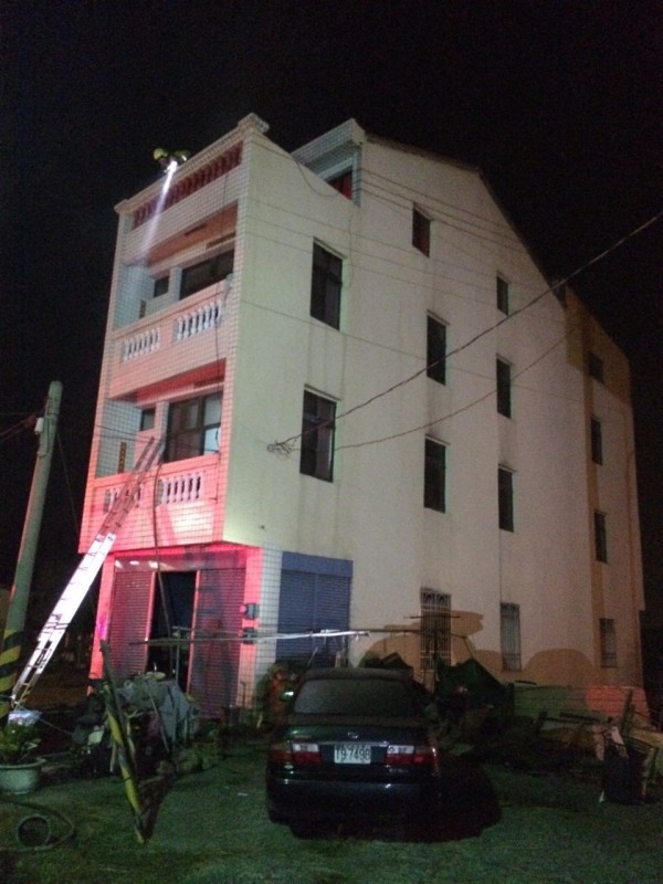 布袋鎮民宅火警，消防人員架梯將受困2樓、3樓及4樓陽台的民眾救下。（記者余雪蘭翻攝）