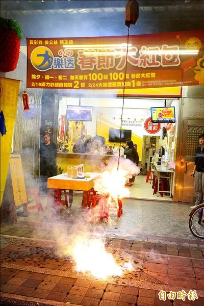 大年初二大樂透頭獎開出三注，其中一注獎落新北市板橋區「府中洺元彩券行」，老闆放鞭炮慶祝。（記者邱柏勝攝）