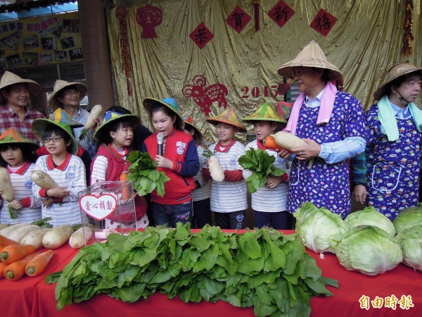 新湖國小學童與教育局長湯志民（右二）一同義賣蔬菜。（記者梁珮綺攝）