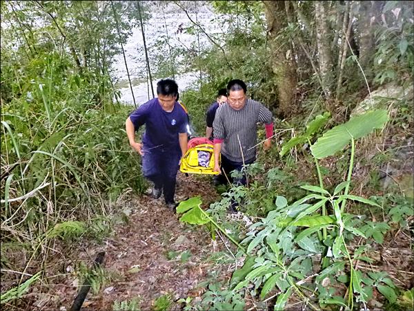 吳姓飛行傘教練由救護和消防人員抬往救護車。（民眾提供）