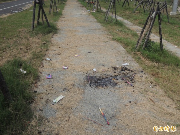 舊河道公園燃散落放過的鞭炮、煙火，環境髒亂不堪。（記者陳燦坤攝）