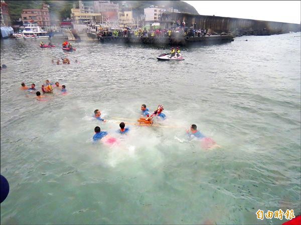 眾勇士無懼寒冷海水抬神轎一躍而下，淨港去邪，為萬民祈福。（記者俞肇福攝）