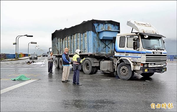 花蓮市中央路新生橋與台九線交會的十字路口發生騎士斷頭死亡車禍，路過的新城鄉長錢自立焦急地在頭顱旁守候。（記者游太郎攝）