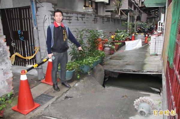 里長林東誼指著下陷的柏油路。（記者徐聖倫攝）