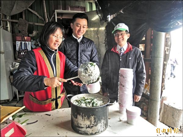 新竹市長林智堅到千甲農場鼓勵原住民栽種的非基改自然農作，強調未來市府將努力推廣友善自然農耕，也對原住民野菜粥很有興趣，親嚐野菜粥味道。（記者洪美秀攝）