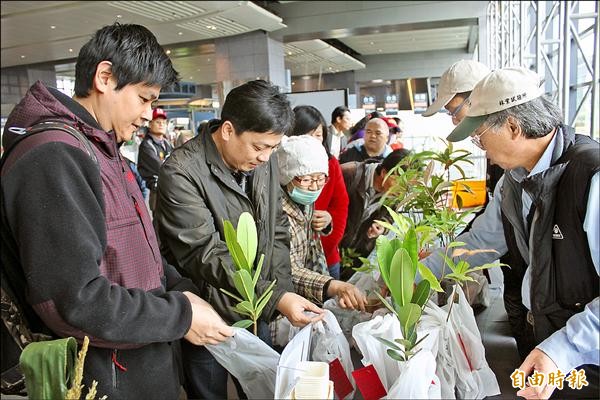 梧桐環境整合基金會與林試所昨在高鐵台中站發送樹苗，並邀民眾寫認養卡，盼培養民眾愛苗的責任心。（記者俞泊霖攝）