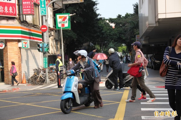 許多機車騎士誤闖遊行管制區，只好牽車步行離開（記者吳昇儒攝）