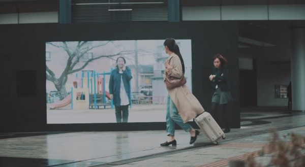 一名女子前往東京打拼事業，經過東京車站外大螢幕時卻突然看到自己的母親現身螢幕為她打氣，讓她感動不已。（圖擷取自YouTube）