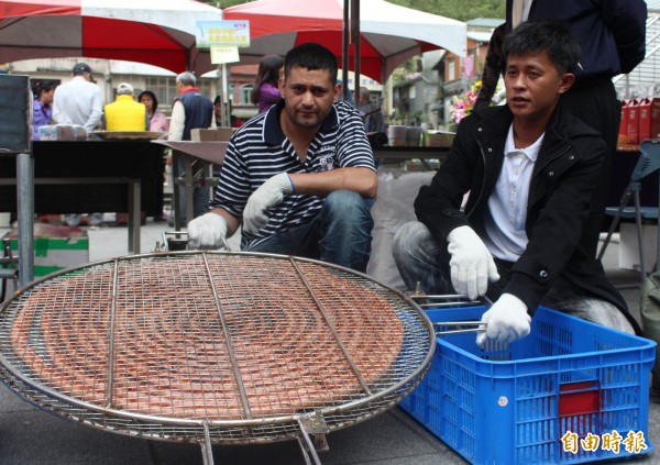 阿力阿力（左）農友蔡健皇（右）一同烘烤長17.5公尺的珠蔥香腸。（記者林欣漢攝）
