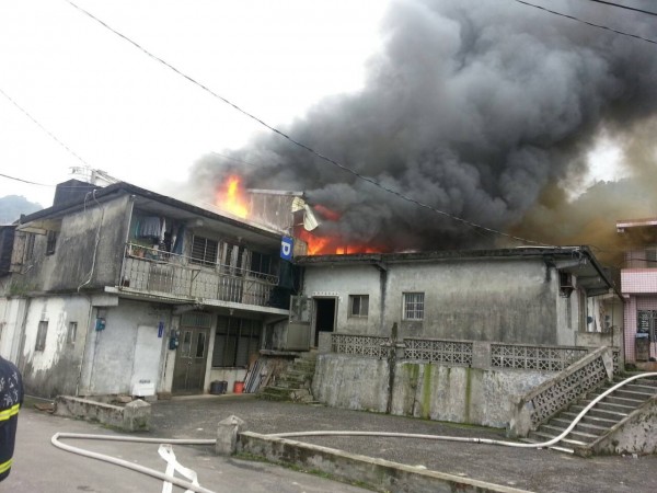 新北市貢寮區文秀坑街一戶2層樓住宅，2 樓鐵皮屋冒出火舌。（記者林嘉東翻攝）