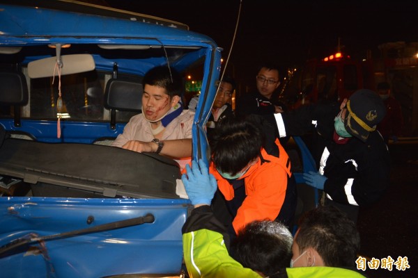 小貨車駕駛（左，臉上有血者）一度卡在車內，被警方救出，所幸無生命危險。（記者朱則瑋攝）