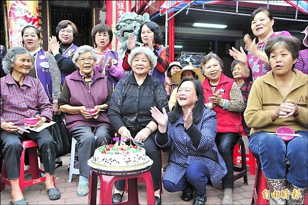 七十六歲阿嬤葉春妹（前排中著黑衣者）過生日，請里民吃水餃、買米濟貧回饋鄉里，兒子還準備大蛋糕現場慶祝。（記者花孟璟攝）