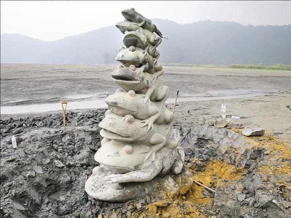 日月潭水位下降，潭區知名景點九蛙疊像因此露出水面，但因九蛙淤沙嚴重，導致第九蛙長期遭「活埋」，管理水庫的台電大觀電廠昨派員清淤，10幾名工人拿著鏟子挖掘污泥，花了好一番工夫才讓第九蛙「重見天日」，惟中午潭區出現雨勢，台電擔心「九蛙泥坑」積水，冒雨開闢排水溝，清淤作業也被迫提早收工。
台電表示，九蛙清淤預計要3天才會完成，將以塑像為圓心，向外半徑5公尺範圍開挖，方便遊客在岸邊步道就能看見九蛙全貌，粗估土方量約25立方公尺，完成清淤後也會幫九蛙「洗澎澎」，盼讓外界欣賞到煥然一新的九蛙面貌。
（圖文：記者劉濱銓）