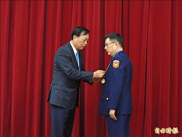 內政部長陳威仁致贈一等內政專業獎章與一等一級警察獎給章王卓鈞。（記者邱俊福攝）