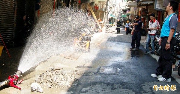 消防局現場拉起封鎖線，架設水線灑水防護。（記者陳文嬋攝）