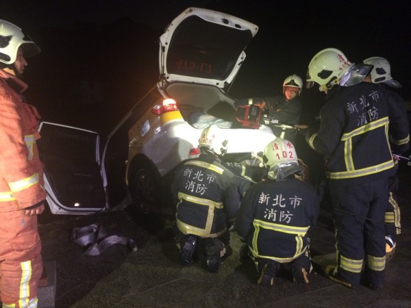 消防單位拉起車頭幾乎墜落魚池的計程車。（記者吳仁捷翻攝）