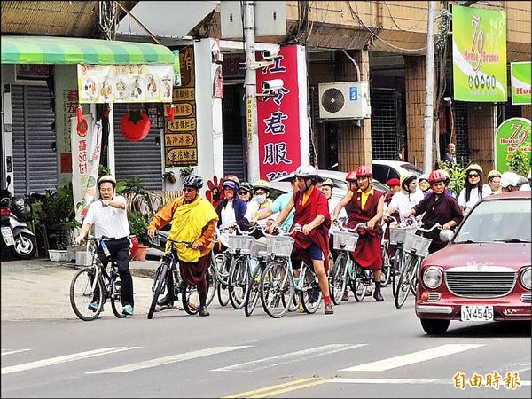 印度嘉旺竹巴法王（左二，著黃色法衣）於高雄市騎單車十五公里。（記者黃旭磊攝）