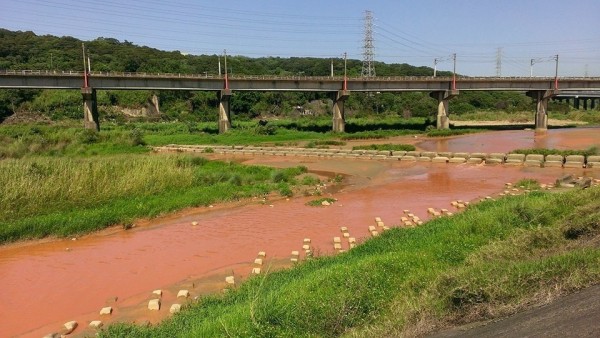 新竹縣民發現，竹北市鳳山溪橋到鐵道橋之間的鳳山溪水昨天出現異常，原本清澈的河水被染成暗紅色。（翻攝自我是竹北人）