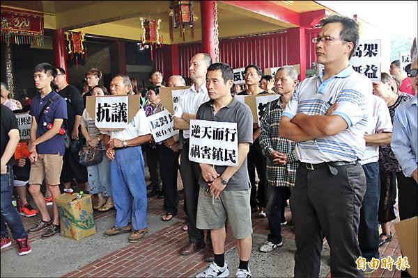 反對育賢街高架橋的鄉親個個面色凝重、手持抗議標語。（記者黃美珠攝）