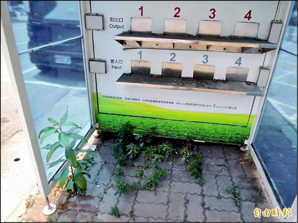 閒置電池交換站變溫室，內部地磚長出植物。（記者王榮祥攝）