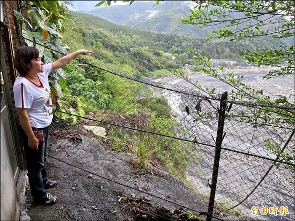 水里頂崁住戶指著被掏空的廚房痕跡（鐵網圍籬外），擔心大雨地震崩塌恐讓他們連人帶屋掉進濁水溪。（記者劉濱銓攝）