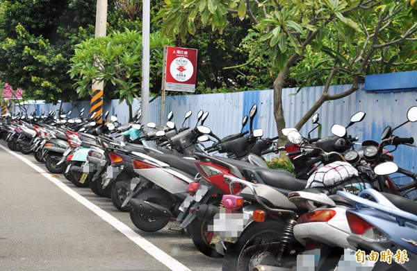 「台灣好行」竹南火車站的起點站牌，被機車包圍，搭乘公車的遊客沒有容身之處，只好排隊上馬路（下圖）。 （記者彭健禮攝）