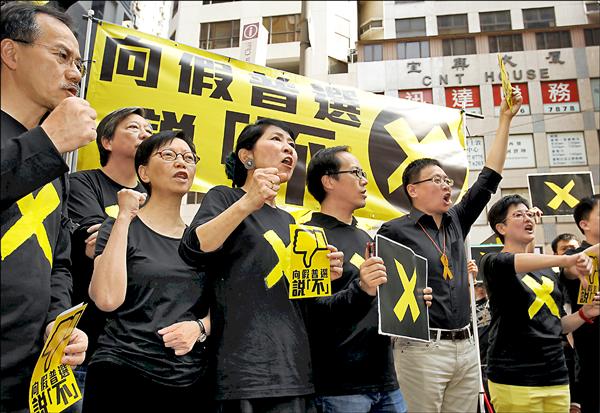 香港立法會泛民主派議員26日走上街頭，啟動「向假普選說不」運動，抗議香港政府日前公布的政改方案。（路透）