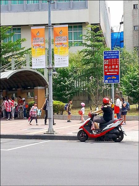 板橋國小後門接送區，被交通局劃成大客車臨時停車格，雖立有告示牌標示不能臨停時間，然效果有限。（記者林郁姍攝）