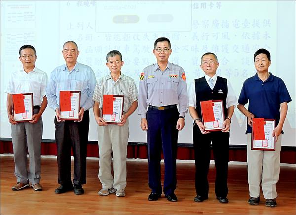 台北市交通大隊隊長吳耀南（右三）昨代表表揚拾金不昧的計程車司機談啟明（右二）等人。（記者郭逸攝）