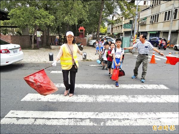 護送學童過馬路，是北辰國小志工媽媽莊秋芬（左）每天最開心的 事。（記者陳燦坤攝）