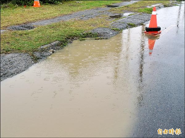 苑裡鎮往通霄鎮台一線北上路段，一處機車行車道逢雨積水，民眾懷疑是排水孔（圖左上）比路面高所致。（記者蔡政珉攝）