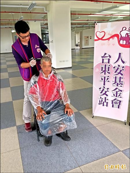 人安基金會台東站長翁任賞看到街友天熱為頭髮煩躁，當起理髮師為街友義務剪髮。（記者王秀亭攝）