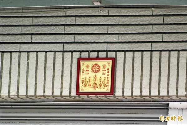 該凶宅門口懸掛符咒辟邪。（記者黃佳琳攝）