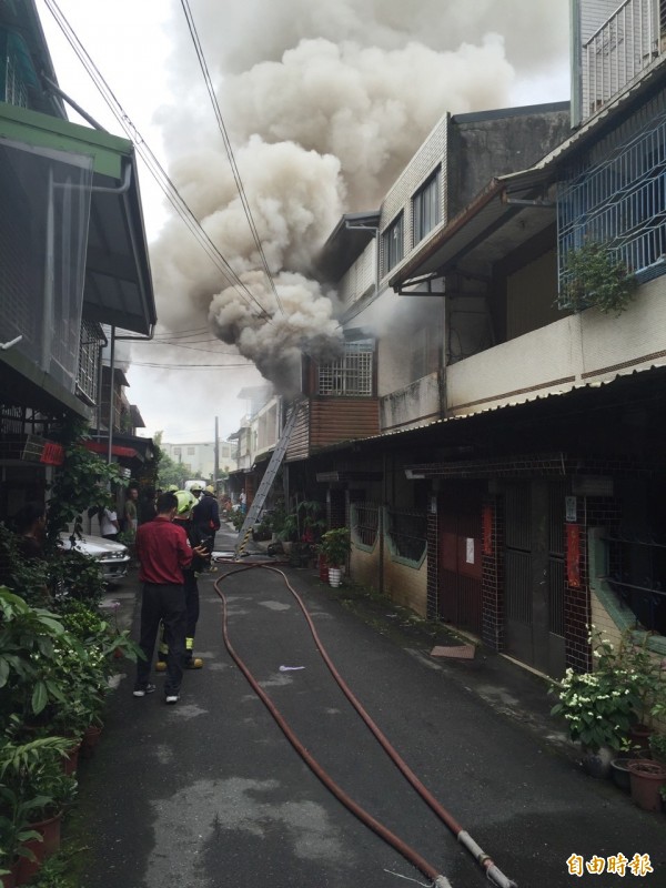 濃煙竄天，嚇得附近居民趕緊逃離屋子。（記者朱則瑋攝）