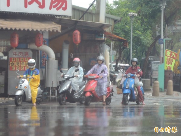 今天上午，台南地區有鋒面帶來降雨，機車騎士紛穿上雨衣。（記者王俊忠攝）