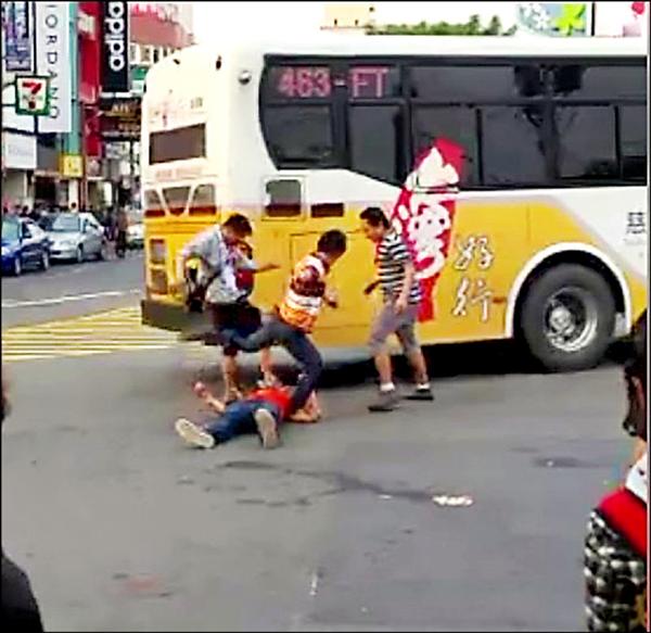 穿著紅衣的泰國勞工險些被經過的公車輾壓。(記者周敏鴻翻攝) 穿著紅衣的泰國勞工險些被經過的公車輾壓。(記者周敏鴻翻攝)