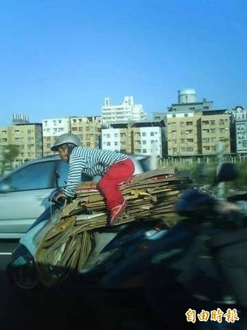 網友po出一張阿嬤趴坐在近1公尺紙箱上騎車的照片。（翻攝自臉書）