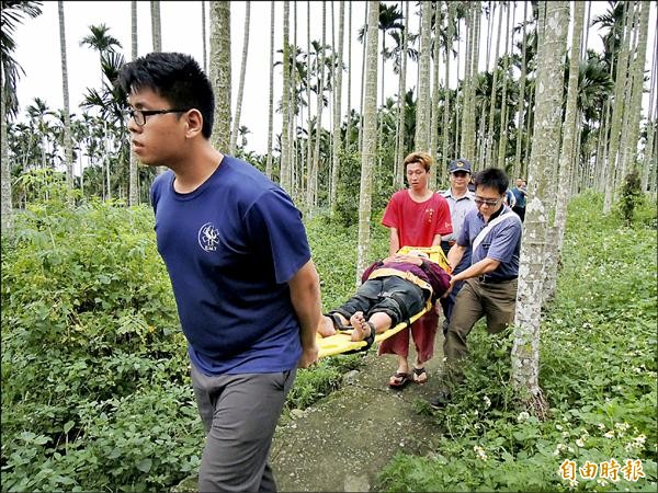 消防隊員以擔架將她抬到救護車上，村民說農路狹窄，婦人竟能把機車騎進去。（記者黃淑莉攝）