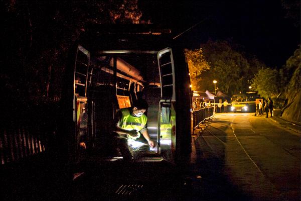 戴上口罩的警方，在麥理浩夫人度假村的聯外道路上設置路障，接受隔離的密切接觸者將在此接受觀察、治療。（路透）