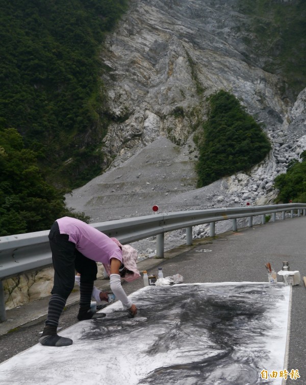 李美慧今於中橫公路白沙橋坍方處作畫「變質的地形」，黑碳深淺潑染筆觸，襯托山勢被無情落石摧毀的險峻。（記者王峻祺攝）