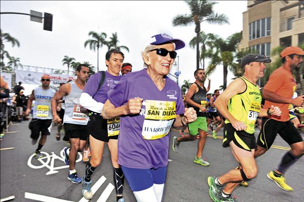 92歲的湯普森5月31日豪邁開跑，以7小時24分完成全程，抵達終點時驕傲地展示獎牌。（美聯社）