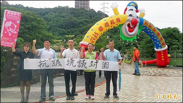 大溪河濱公園舉辦熱氣球活動惹民怨，桃園市議員陳治文（右二）和里民在活動入口處拉起抗議布條。（記者李容萍攝）